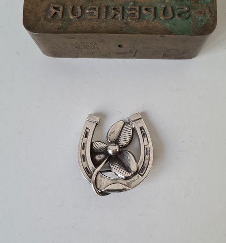 Vintage silver brooch in the form of horseshoes with three-leaf clover