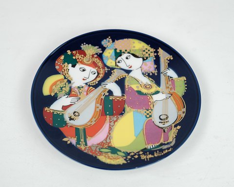 Farverig platte designet af Bjørn Wiinblad produceret af Rosenthal. Orientalsk 
natmusik motiv nr. 2. Mål i cm: Dia: 15
Flot stand
