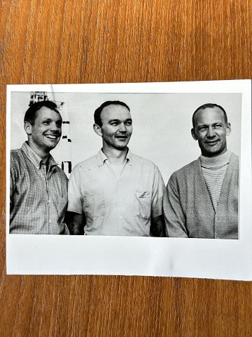 NASA: Lille, originalt sort/hvidt foto, af de tre Apollo 11-astronauter Neil 
Armstrong, Mike Collins og Edwin Aldrin, gelatin silver, juli 1969 med Apollo 
V-raketten i baggrunden