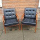 Pair of teak armchairs with black leather cushions