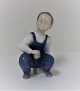 Bing & Grøndahl. Porcelænsfigur. Siddende dreng. Model 2402. Højde 12 cm. (1 
sortering)