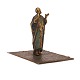Figurine in the shape of a man on a carpet. H: 9,5cm. Base: 9x11cm